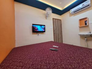 a bedroom with a bed with a remote control on it at Swapnpurti yatri niwas in Kolhapur