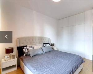 ein Schlafzimmer mit einem großen Bett und einer weißen Wand in der Unterkunft Klinger apartment in Bratislava