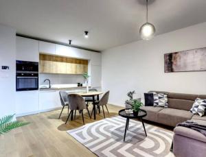 ein Wohnzimmer mit einem Sofa und einem Tisch in der Unterkunft Klinger apartment in Bratislava