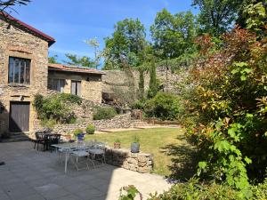 a patio with a table and chairs in a yard at Domaine de Pipangaille in Andancette