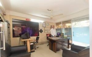 a man standing in an office with a desk at Skyline Lodge in Siliguri