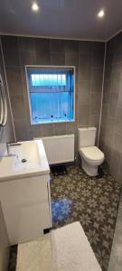 a bathroom with a sink and a toilet and a window at Benllech Sea View bungalow, Dog Friendly sleeps 6 in Benllech