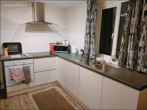 a kitchen with a sink and a microwave at Woodies in Peasmarsh