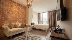 a room with a couch and a bed and a brick wall at Celine Living - Central in Ho Chi Minh City