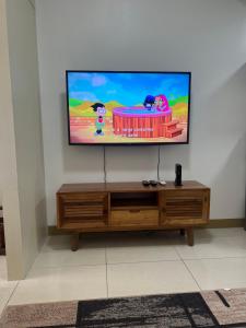a flat screen tv sitting on top of a wooden entertainment center at Fully Furnished 1 bedroom Condo Las Pinas in Manila
