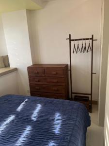 a bedroom with a blue bed and a dresser at Fully Furnished 1 bedroom Condo Las Pinas in Manila