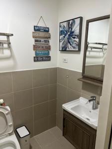 a bathroom with a sink and a toilet and a mirror at Fully Furnished 1 bedroom Condo Las Pinas in Manila