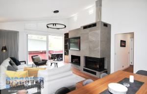 a living room with a white couch and a fireplace at Squatters Run 6 in Thredbo