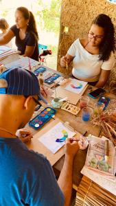 拉巴拉德納聖米格爾的住宿－EcoMar - Pousada de Experiência，一群坐在桌子上制作工艺品的人