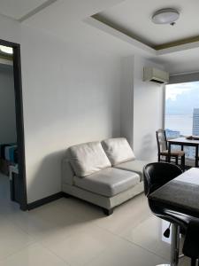 馬尼拉的住宿－1 BR with balcony, fully furnished overlooking Manila Bay at Birch Tower, Malate, Manila，客厅配有沙发和桌子