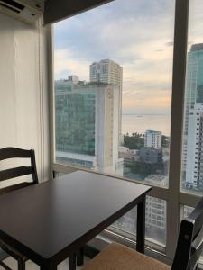 馬尼拉的住宿－1 BR with balcony, fully furnished overlooking Manila Bay at Birch Tower, Malate, Manila，配有大窗户的客房内的桌椅
