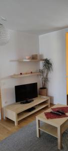 uma sala de estar com uma televisão de ecrã plano sobre uma mesa em Apartma 198 em Kranjska Gora