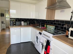 a kitchen with a stove and a washing machine at SEAVIEW self-catering coastal bungalow in rural West Wight in Freshwater