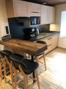 een keuken met een houten tafel en een aantal stoelen bij Chalet 3 Céline 6 personnes Vieux Village in Bonneval-sur-Arc