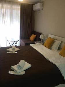 ein Hotelzimmer mit einem großen Bett mit Handtüchern darauf in der Unterkunft Jorjadze street 23 in Bordschomi