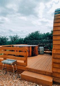 a wooden deck with a bench and a table at Crabmill Glamping with hot tub in Bewdley