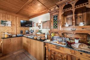 uma cozinha com armários de madeira e um balcão com comida em Haus Hochland em Tux