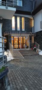 a house with a porch and stairs in front of it at Hotel Aqua Sárvár in Sárvár