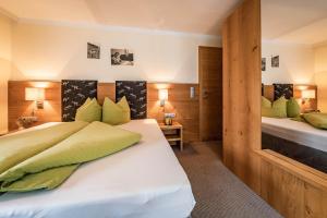 a bedroom with a large white bed with green pillows at Haus Hochland in Tux