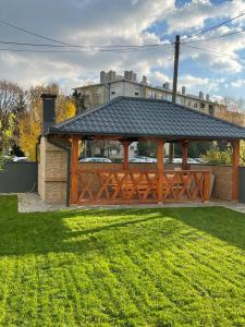 a wooden gazebo with a black roof at Apartmani Daisy in Velika Gorica