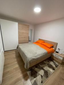 a bedroom with a bed with orange pillows on it at Apartmani Daisy in Velika Gorica
