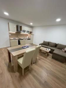 a living room with a table and chairs and a couch at Apartmani Daisy in Velika Gorica