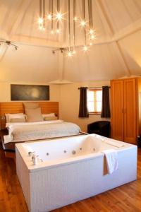 1 dormitorio con bañera grande frente a la cama en Cheshire Cat en Nantwich
