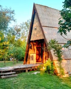 Cabaña de madera con techo de paja en Casone Maranghetto, en Marango di Caorle – Casa Pace