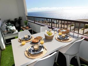 a table with food and a view of the ocean at Luxury Flat to the Atlantic Ocean in Radazul