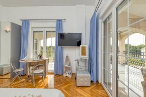 um quarto com uma cama, uma mesa e uma varanda em Apartments Covic em Antonci