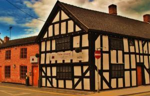 een zwart-wit gebouw aan de straatkant bij Cheshire Cat in Nantwich