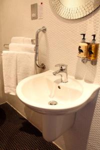 a bathroom with a white sink and towels at Cheshire Cat in Nantwich