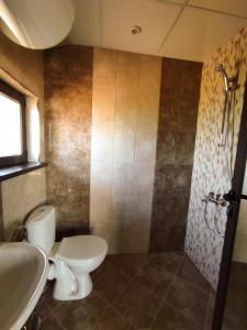 La salle de bains est pourvue de toilettes, d'un lavabo et d'une douche. dans l'établissement Къща за гости Даниела, à Lozenets