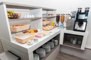 a kitchen with a shelf with food and dishes at Hotel Fine Harmony in Amsterdam