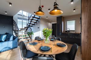 a dining room and kitchen with a wooden table and chairs at Family Resort Ustka - Domki dwupoziomowe z basenem in Ustka