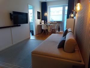 uma sala de estar com uma cama e uma televisão em Cosy little apartment em Munique