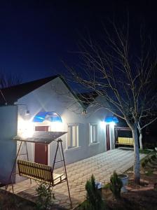 uma casa branca com luzes azuis à noite em zaza house em Kutaisi