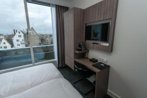 une chambre d'hôtel avec un lit et une télévision dans l'établissement Hotel Fine Harmony, à Amsterdam