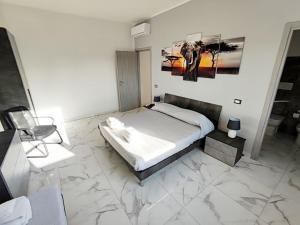 a bedroom with a large bed with marble floors at Intero Appartamento Casa Vacanze ''il Pino'' Roma in Infernetto