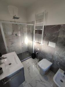 a bathroom with a shower and a toilet and a sink at Intero Appartamento Casa Vacanze ''il Pino'' Roma in Infernetto