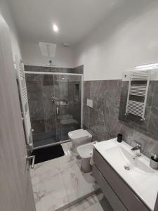 a bathroom with a toilet and a sink and a shower at Intero Appartamento Casa Vacanze ''il Pino'' Roma in Infernetto