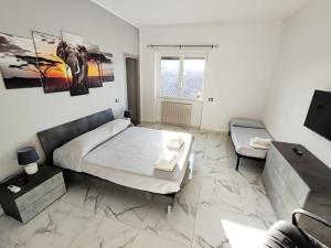 a bedroom with a king sized bed and a couch at Intero Appartamento Casa Vacanze ''il Pino'' Roma in Infernetto