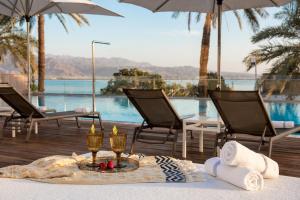 a table with candles and chairs and a pool at Astral Maris Hotel in Eilat