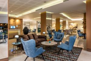 een lobby met blauwe stoelen en een bank bij Astral Maris Hotel in Eilat