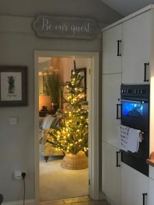 een kerstboom in een kamer met een deur bij The Lodge at The Cedars in Stourbridge