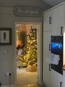 a christmas tree is in a room with a door at The Lodge at The Cedars in Stourbridge