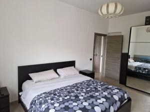 1 dormitorio con 1 cama grande y espejo grande en La casa di Andrea en Messina