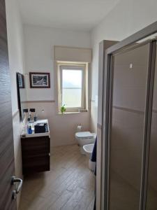 a bathroom with a toilet and a window at La casa di Andrea in Messina