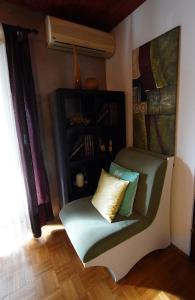 a green chair with two pillows sitting in a room at Roba's Apartment in Zagreb