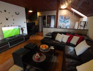 a living room with a couch and a flat screen tv at Roba's Apartment in Zagreb